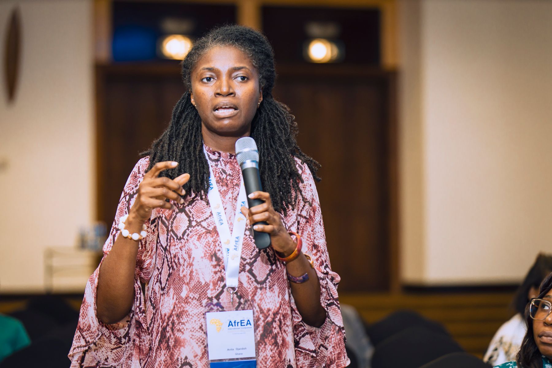 A woman speaking into a microphone at a conference