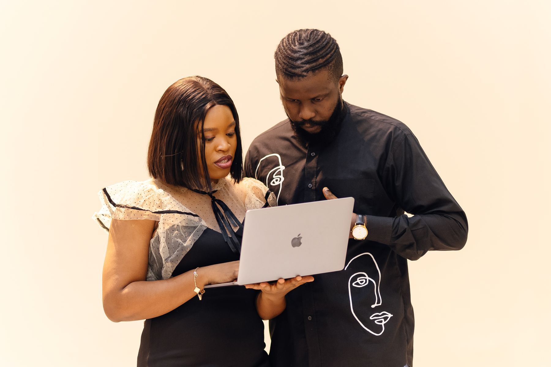 Two young professionals working together on a laptop