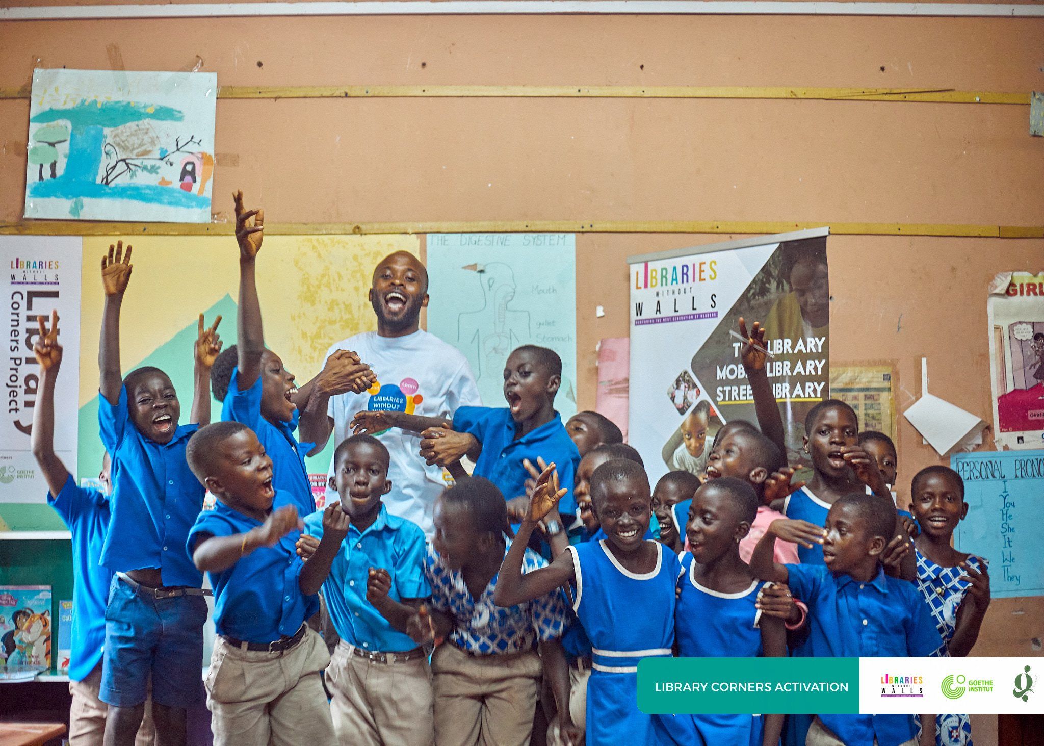 Pupils cheering with their arms raised in their new library corner