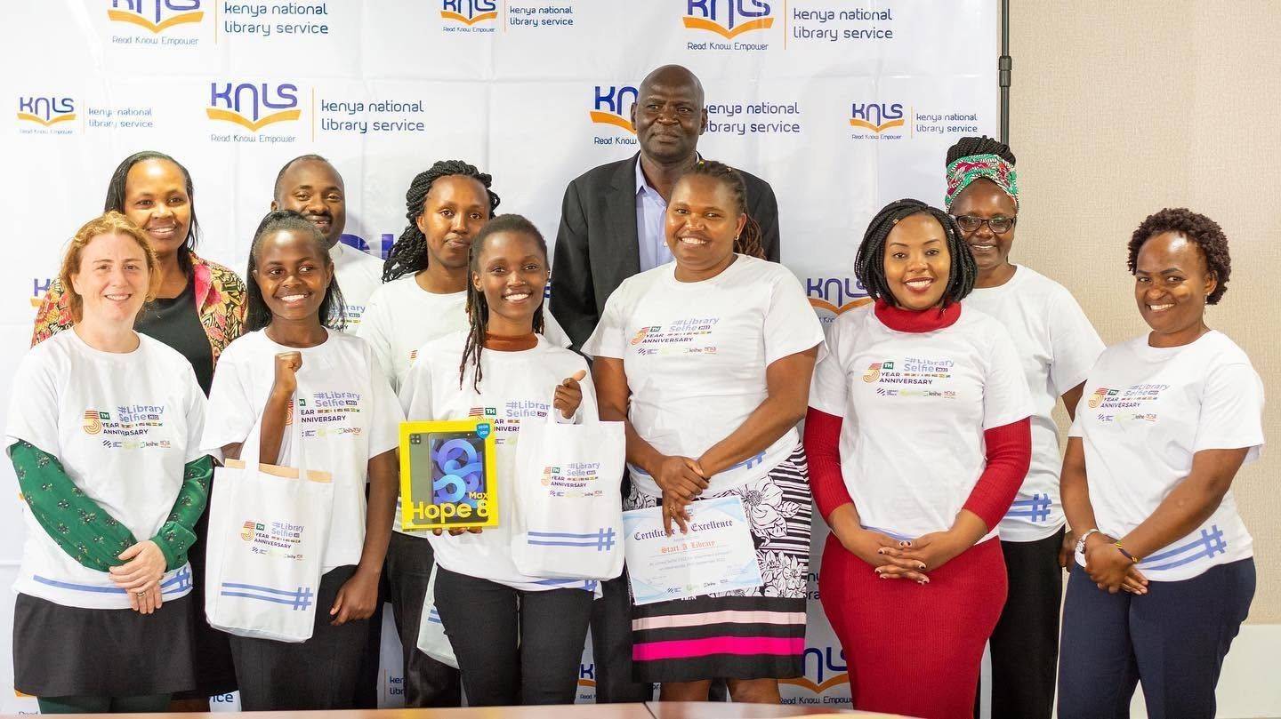 Participants holding certificates and gift bags at a Kenya National Library Service event
