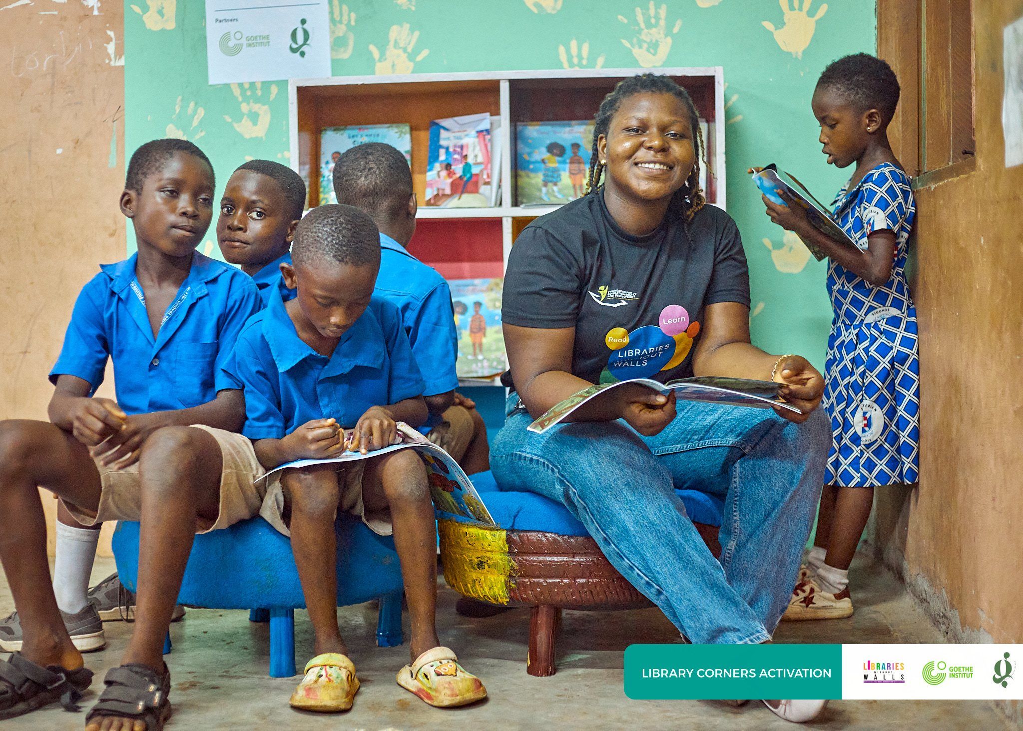 A volunteer sharing books with pupils in a school library corner