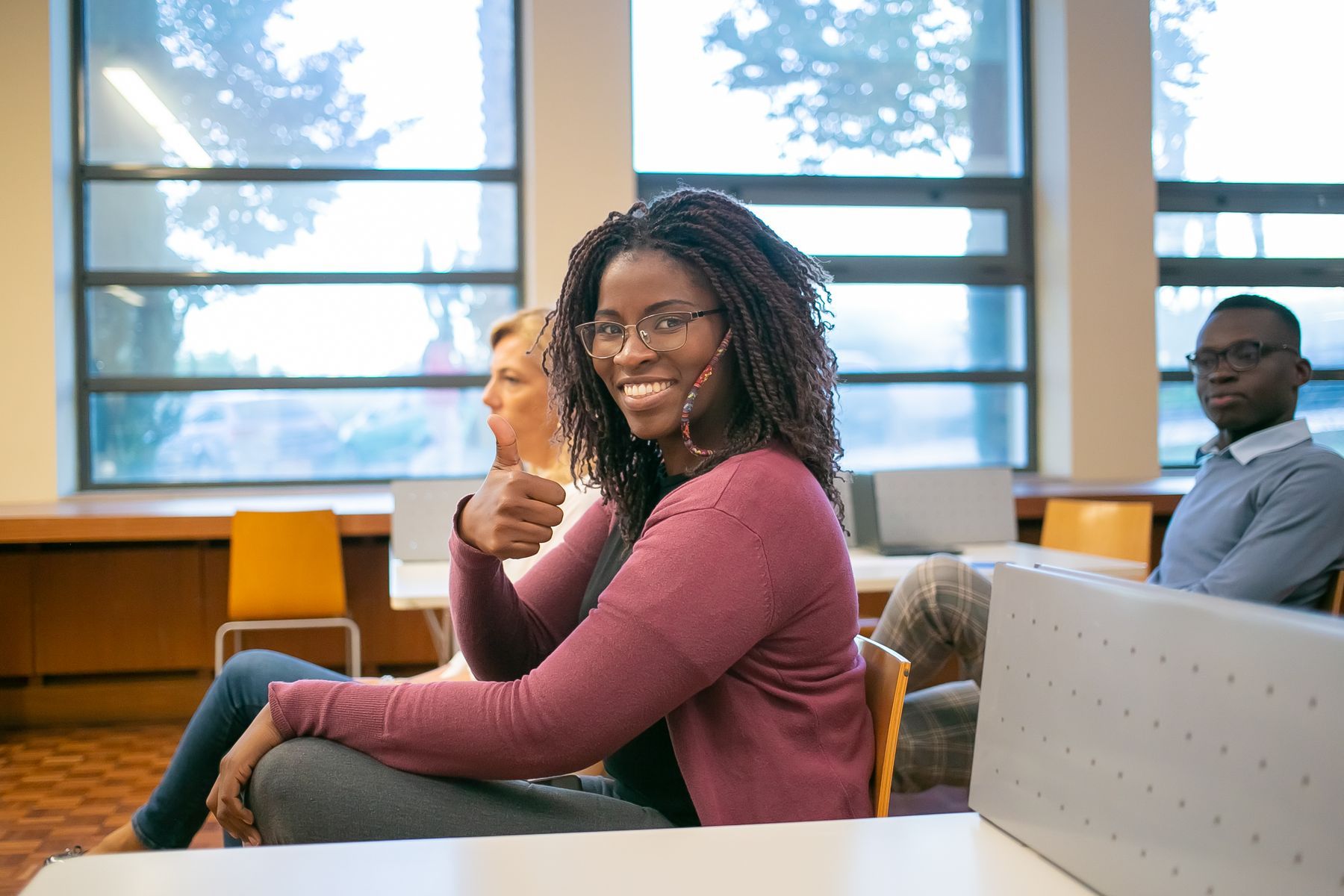 A smiling woman in a bright, modern library